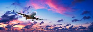 Featured image airfares inflationary spike airplane taking off against pink sunset sky